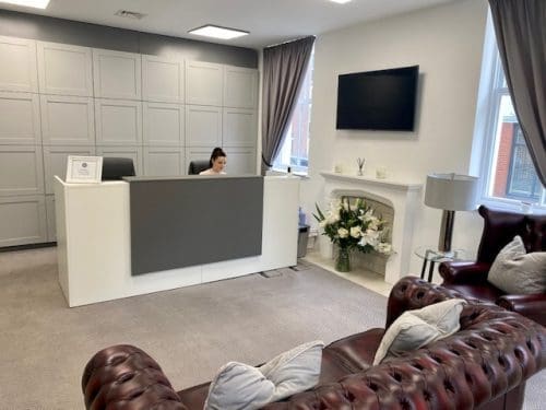 Grosvenor lobby, leather sofa with desk and fireplace