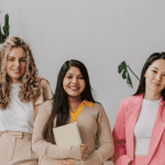 Three women in stylish outfits posing for the Live and Lead event.